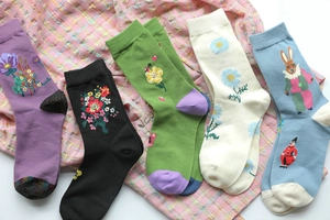 Detailed view of five pairs of cotton ankle socks with unique floral and animal patterns