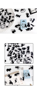 Macro view of vintage hand-drawn black cat stickers with blue paper box packaging