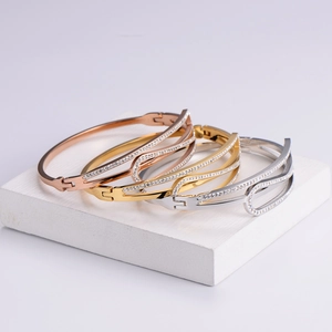Minimalist rhinestone inlaid bracelets in rose gold, gold, and silver on stone display