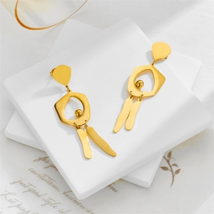 Polished gold geometric irregular long drop earrings on white marble tray