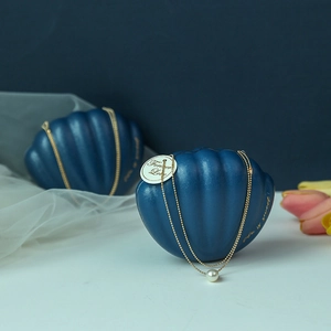 Creative shell-shaped blue wedding candy box with a gold pearl necklace and elegant finish