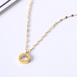Detail of gold necklace pendant with roman numerals and sparkling crystal centerpiece