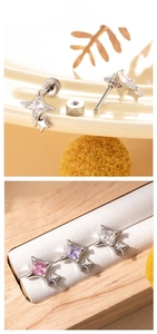 Detail of star-shaped titanium steel ear studs with colorful square crystals and screw backs
