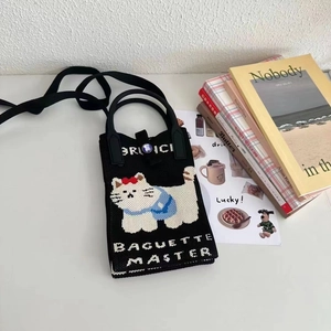Vue détaillée du sac à téléphone en tricot avec motif chat mignon et texte tissé