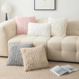 Plush faux fur decorative pillow covers in various colors on a modern sofa