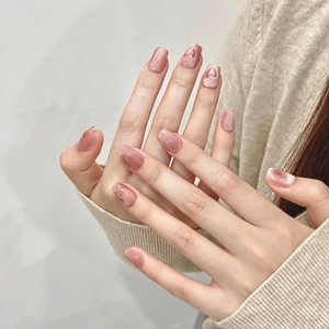 Cat eye pink press-on nails with 3D heart design and shimmering light effect