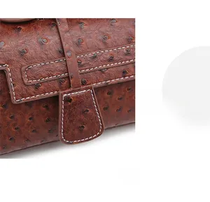 Close-up of brown ostrich leather texture with white contrast stitching on bag