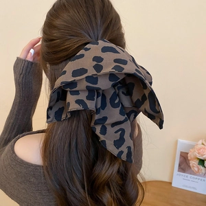 Dettaglio del fermaglio per capelli a fiocco leopardato oversize indossato