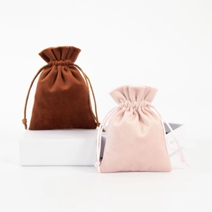 Detailed view of pink and brown velvet drawstring pouches in two different sizes
