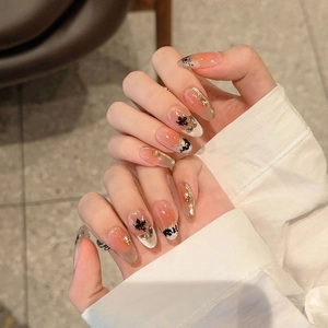 Handcrafted maple leaf press-on nails with butterfly motifs and 3D gold details