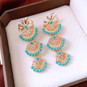Gros plan détaillé de boucles d'oreilles vintage avec perles bleu ciel et strass brillants