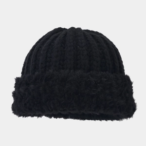Detail einer schwarzen Strickmütze mit dickem Kunstfell-Umschlag für winterliche Wärme