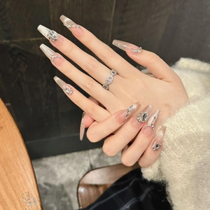 Faux ongles faits main longs cercueil rose nude avec vernis œil de chat et strass brillants