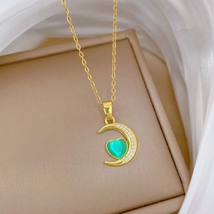 Elegant gold crescent moon necklace with green heart gem and sparkling zircon accents