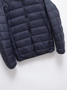Detailed close-up of navy blue quilted puffer jacket fabric and durable zipper closure