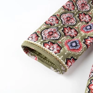 Detailed view of quilted cotton sleeve with ethnic paisley print and woven trim edges