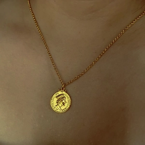 Détail macro du collier pendentif pièce 18K avec figure gravée et texture vintage