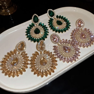 Detailed view of colorful teardrop flower earrings with radiant rhinestones in a white tray