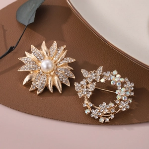 Vue détaillée de broches fleur de tournesol dorées avec perles et cristaux sur cuir