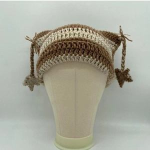 Detail of hand-knitted cat ear hat featuring brown stripes and star pendant tassels