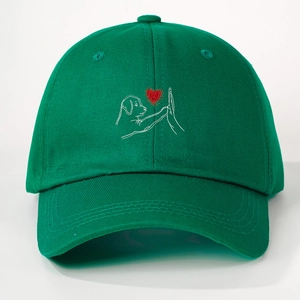 Detailed view of green baseball cap with embroidered puppy high-five heart logo