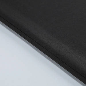 Close-up of fine black knit fabric texture and high-quality seam detail of the set