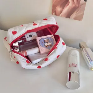 Quilted white cosmetic bag with red heart pattern showing spacious internal storage