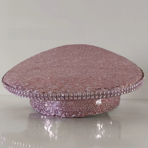 Close-up of pink sequined military hat featuring sparkling rhinestone trim on the brim