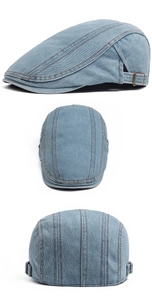 Detail of light blue denim beret with orange contrast stitching and metal buckle side