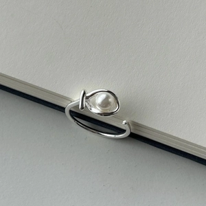 Minimalist 925 sterling silver open ring with 6mm pearl on a white notebook edge