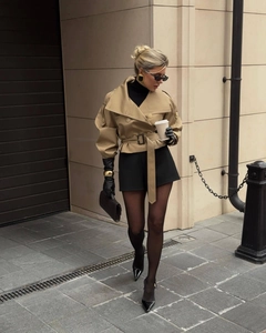 Détail d'un coupe-vent court kaki avec ceinture à nouer et des manches bouffantes