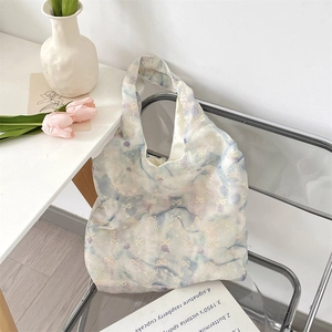 Detail of floral embroidery and bow knot on watercolor gradient organza tote bag