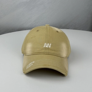 Detailed view of khaki canvas baseball cap with embroidery and distressed brim details
