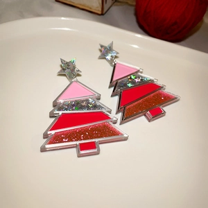 Detail of Christmas tree acrylic earrings with pink and red glitter and silver star charms