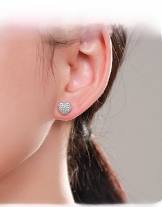Close-up of S925 sterling silver heart stud earrings with pavé zircons on model ear