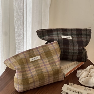 Detail of vintage plaid wool makeup bags with zipper closure and woven logo label
