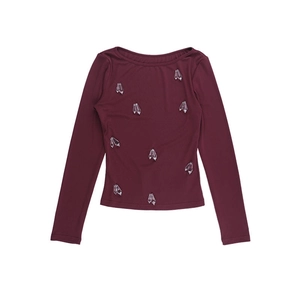 Detail of burgundy ribbed long sleeve top with sparkling crystal rhinestone embellishments