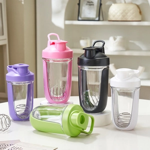 Various colored protein shaker bottles with metal mixing balls on a table