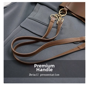 Detail view of smooth dark brown leather texture and golden metal hardware on tote bag