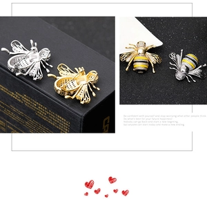 Detailed macro view of bee brooches with zircon inlay and yellow enamel on black gift box