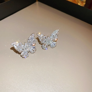 Macro shot of silver butterfly ear cuffs featuring shimmering zircon inlay and luxury details