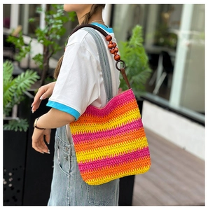 Detailed close-up of rainbow striped straw shoulder bag with elegant wooden bead handles