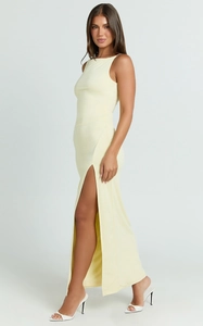 Detail view of the elegant side slit and slim fit of this yellow sleeveless maxi dress