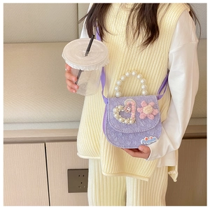 Detail of purple embossed heart girl's bag with pearl handle and floral decoration
