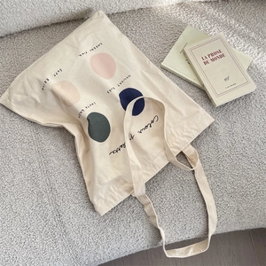 Detail of canvas tote bag with color palette print on soft textured background