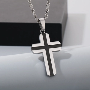 Détail macro du pendentif croix en acier inoxydable argenté avec bande noire sur chaîne