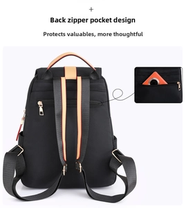 Detail of black oxford backpack with anti-theft back pocket and red striped straps