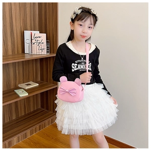 Pink cartoon cat crossbody bag with bow detail worn by girl in white mesh skirt
