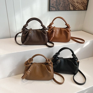 Chic pleated croissant handbag in four retro colors displayed on a minimalist staircase