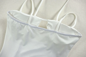 Detailed view of the inner lining and chest pad slot design on white knitted dress